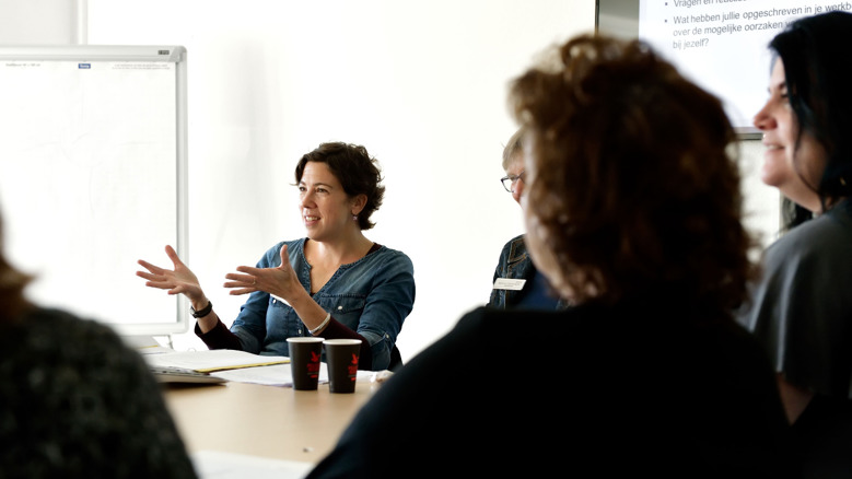 Therapeuten en cliënten zitten rond een tafel